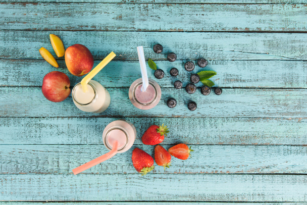 milkshakes in glazen flessen met bessen en vruchten - Foto, afbeelding