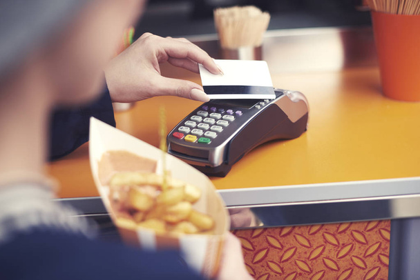 Dama, płacąc za niezdrowej żywności za pomocą karty kredytowej  - Zdjęcie, obraz