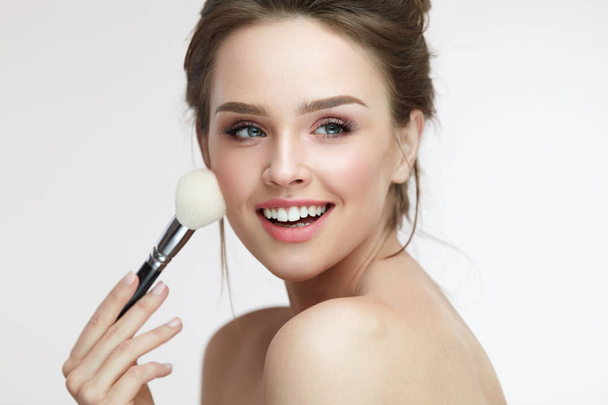 Beauty Face Makeup. Beautiful Smiling Girl Applying Loose Blush - Fotoğraf, Görsel