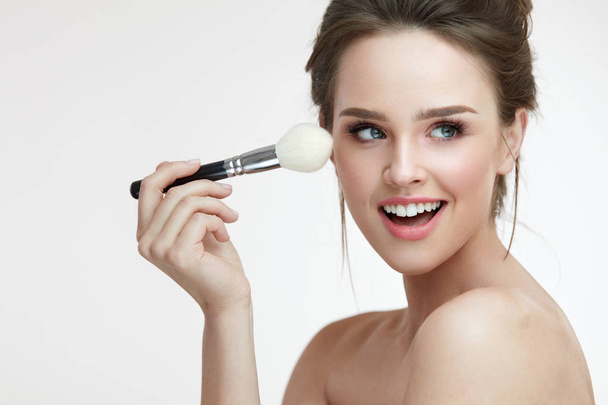 Beauty Face Makeup. Beautiful Smiling Girl Applying Loose Blush - Фото, изображение