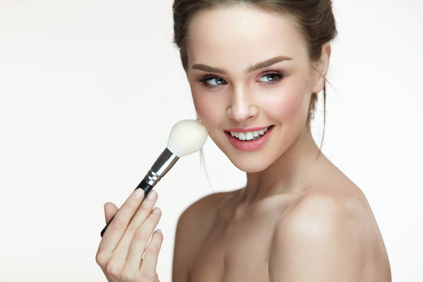 Beauty Face Makeup. Beautiful Smiling Girl Applying Loose Blush - Fotoğraf, Görsel