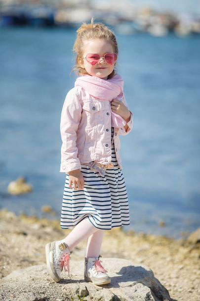 Fashionable little girl in pink sunglasses. The concept of summer vacations - Foto, Bild