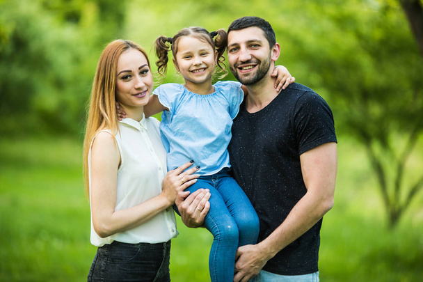 Happy young mother, father and daughter in summer park - Photo, Image