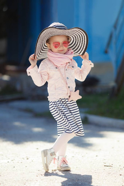 Fashionable little girl wearing a hat and sunglasses. summer vacation concept - Фото, изображение