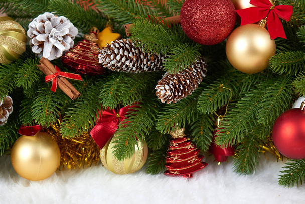 Kerstdecoratie op fir tree branch close-up, geschenken, xmas bal, kegel en andere objecten op witte lege ruimte bont, concept van de vakantie, plaats voor tekst - Foto, afbeelding