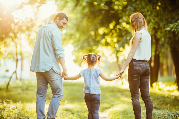 feliz familia caminando al aire libre en verano parque puesta de sol
 - Foto, imagen