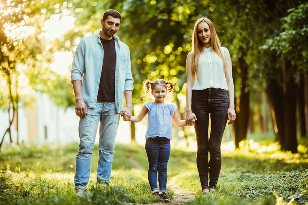 Mother, father and little girl walking in summer park and having fun - Photo, Image