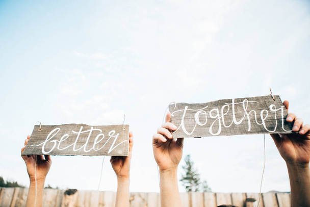 Männliche und weibliche Hände halten Holztafeln mit Text besser zusammen, Hochzeitstagskonzept - Foto, Bild