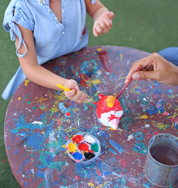 Child painting, Portrait little girl having fun to paint on stucco doll - 写真・画像