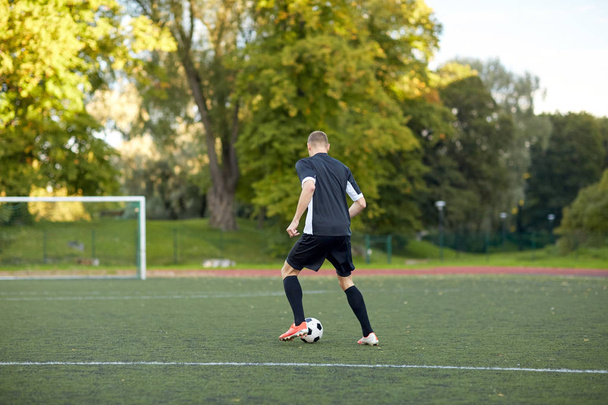 Fußballer spielt mit Ball auf Fußballplatz - Foto, Bild