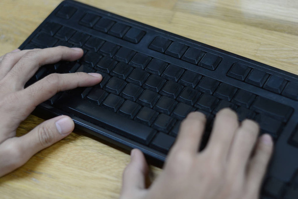 handen type op toetsenbord met houten tafel  - Foto, afbeelding