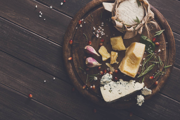 Cheese delikatessen on rustic wood, blue roquefort, brie and parmesan - Foto, Imagem