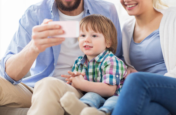 happy family with smartphone at home - Foto, afbeelding