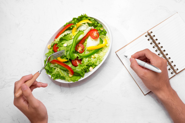Notizblock, Stift und Gabel mit frischem Salat - Foto, Bild