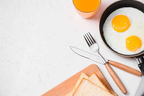  жареные яйца, хлеб и апельсиновый сок
  - Фото, изображение