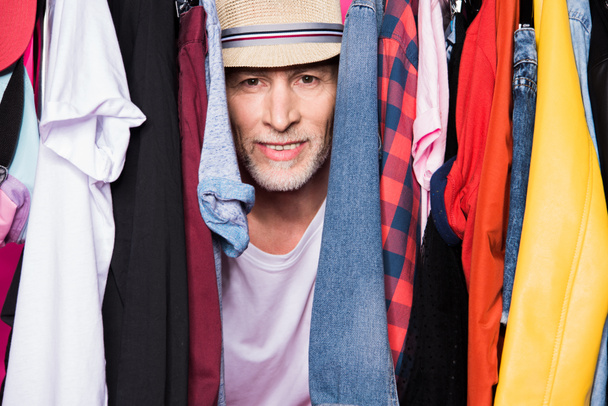 senior man with diferent clothes on hangers - Photo, Image