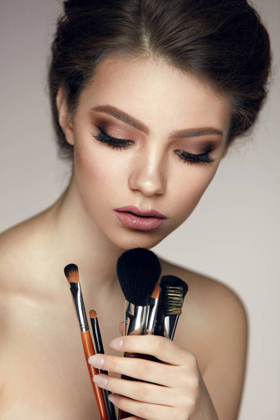 Makeup Cosmetics. Glamorous Beautiful Woman Holding Brushes - Photo, Image