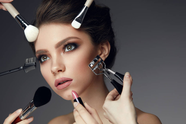 Beauty Face Makeup. Closeup Female With Cosmetic Tools Near Face - Foto, imagen