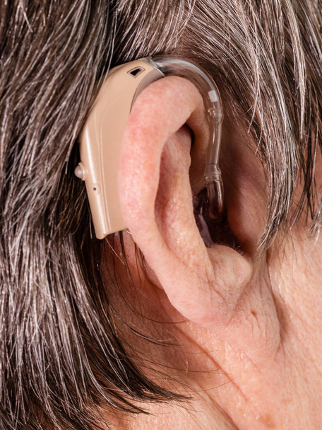 Closeup senior woman using hearing aid - Фото, зображення
