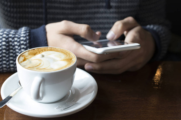 πίνοντας καφέ με το κινητό τηλέφωνο  - Φωτογραφία, εικόνα