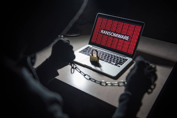 Ordenador de bloqueo hacker masculino mediante el uso de la cadena y el candado
 - Foto, imagen