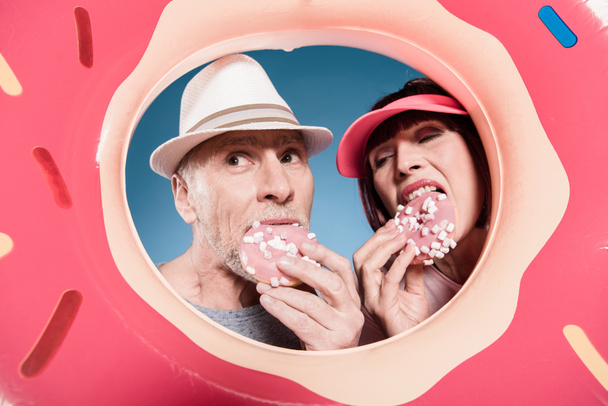 pareja de ancianos comiendo donas dulces
 - Foto, Imagen