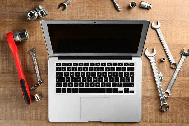 Laptop and tools for car repair  - Фото, изображение