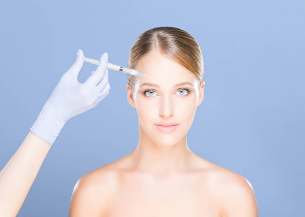 Doctor making injection into face of woman - Fotoğraf, Görsel