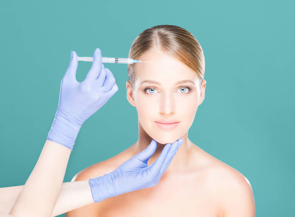 Doctor making injection into face of woman - Photo, image
