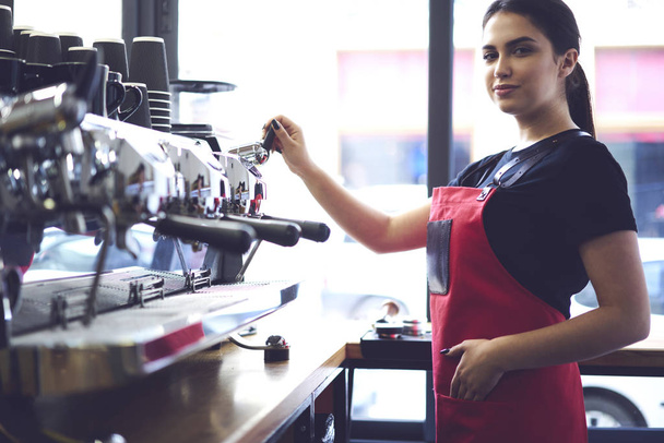 Female barista checking coffee machine   - Foto, Bild