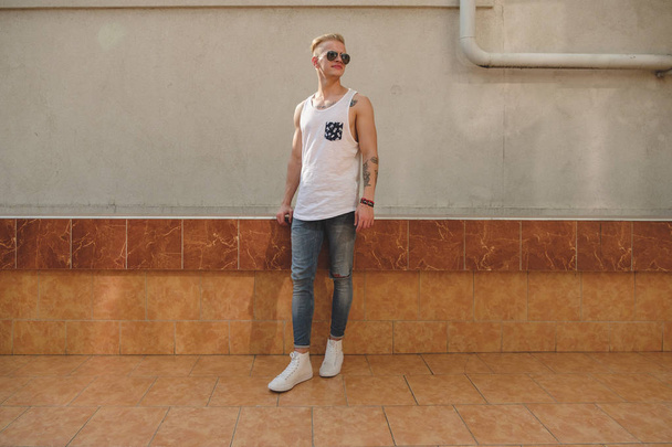 Hipster handsome blonde man guy in stylish summer clothes in the street - Foto, imagen