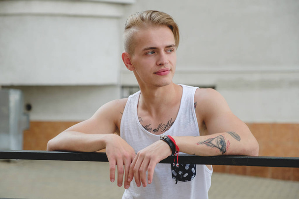Hipster knappe blonde man man in stijlvolle zomer kleding in de straat - Foto, afbeelding