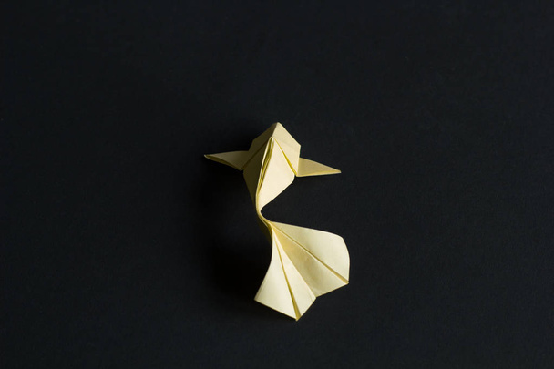 Papel hecho a mano artesanal origami amarillo koi carpa pescado sobre fondo negro. Vista trasera
 - Foto, imagen