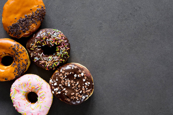 Glazed donuts on dark background - Фото, изображение