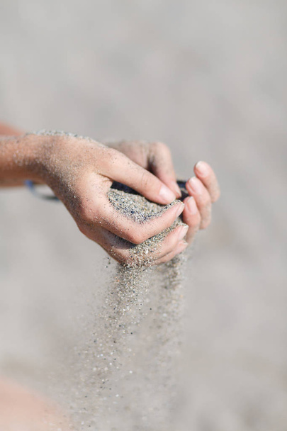 Молодая женщина с песком в руках
 - Фото, изображение