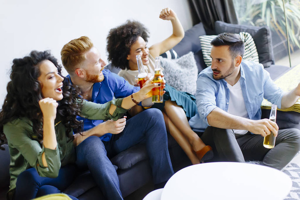 Друзья смотрят телевизор и пьют сидр
 - Фото, изображение