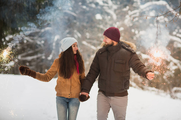 Young happy couple in love outdoors in the winter with sparklers - Photo, Image