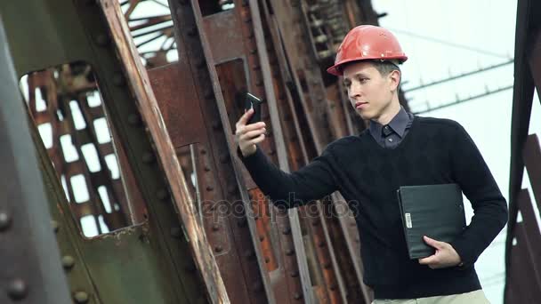 Ingenieur bouwkunde in helm maakt selfie op de telefoon - Video