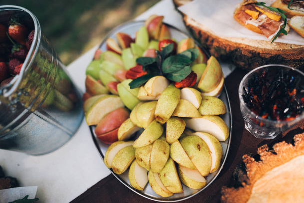 Big dish with different fresh fruits. Sliced fruit pear - Фото, изображение