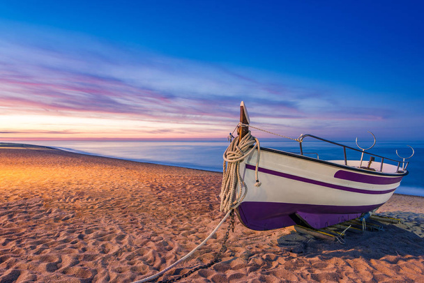 Vanha puinen kalastusvene rannalla auringonnousun aikaan
 - Valokuva, kuva
