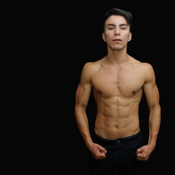 Young latino man in black pants, shirtless looking from front - Photo, Image