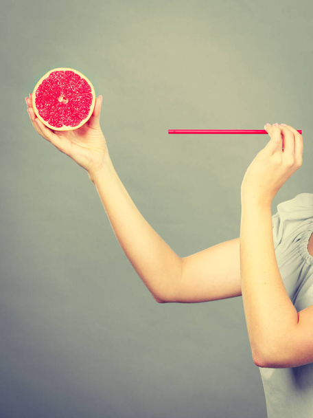 Woman drinking juice from fruit, red grapefruit - Fotoğraf, Görsel