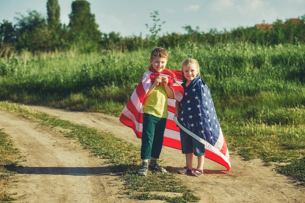 μια πραγματικά πατριωτική παιδιά με σημαία των ΗΠΑ. Η έννοια της ημέρα της ανεξαρτησίας - Φωτογραφία, εικόνα