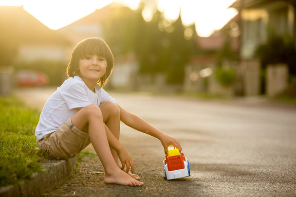 Симпатична мила дитина, хлопчик, грає з іграшками на машині на вулиці в Ві
 - Фото, зображення