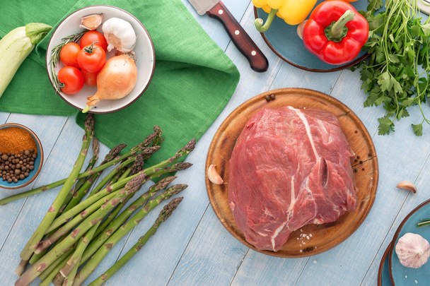 Fresh beef tenderloin with different vegetables on blue wooden t - Valokuva, kuva