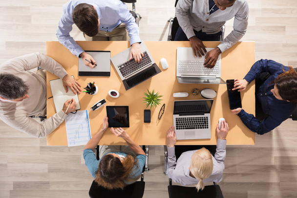 Вид сверху на бизнесменов, работающих вместе в офисе
 - Фото, изображение