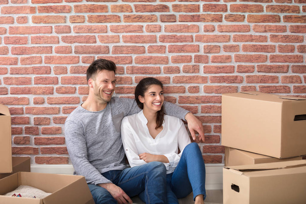  couple sitting between cardboard boxes - Photo, Image