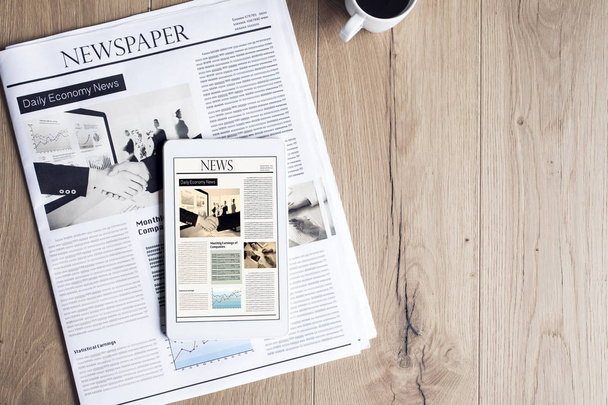 Newspaper with tablet on wooden table - Photo, Image