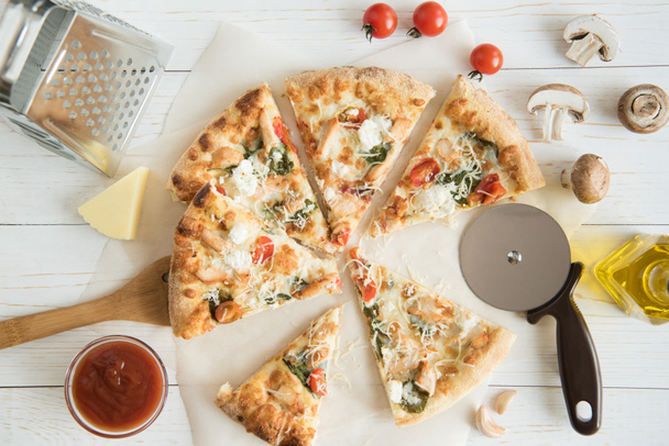 pizza rebanada con queso y utensilios de cocina
 - Foto, imagen