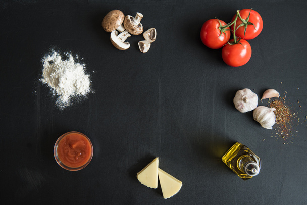 ingredientes para preparar pizza en la superficie oscura
 - Foto, Imagen